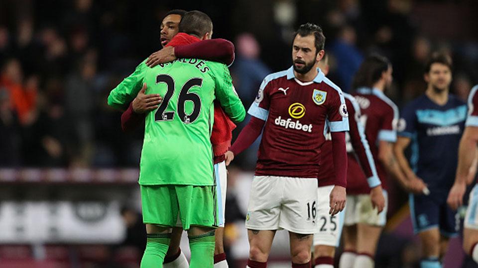 Victor Valdes berpelukan dengan pemain Burnley setelah pertandingan. - INDOSPORT